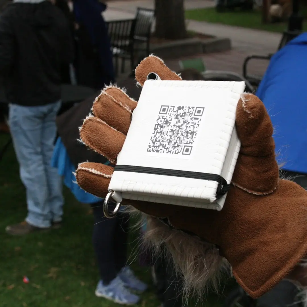 Printed QR at a physical station with a phone scanning it